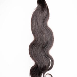 Wavy dark hair extension with loose curls.