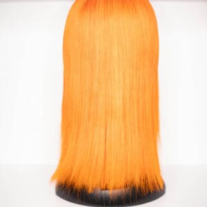 Vibrant orange wig displayed on a stand.